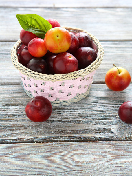  wicker basket full of ripe plums - Foto, Bild