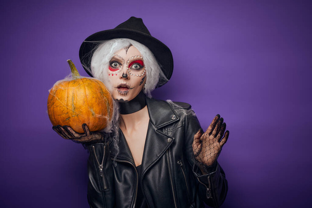 Allegro giovane donna in costume di Halloween con zucca in mano - Foto, immagini