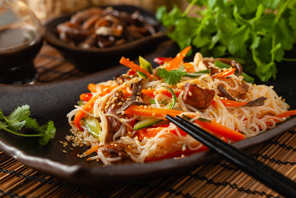 Oriental salad with rice noodles, chicken and mint. Front view. - 写真・画像