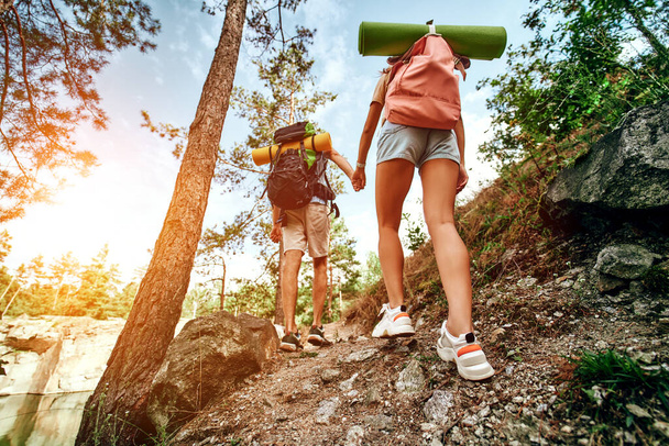 Um casal amoroso de turistas com mochilas subir os picos rochosos na floresta. Caminhadas, viagens, caminhadas. - Foto, Imagem