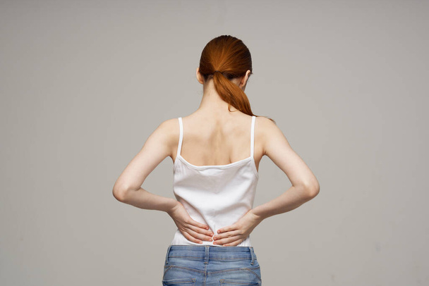Hafif arka planda eklemlerinde ağrı belirtileri olan huysuz bir kadın. Yüksek kalite fotoğraf - Fotoğraf, Görsel