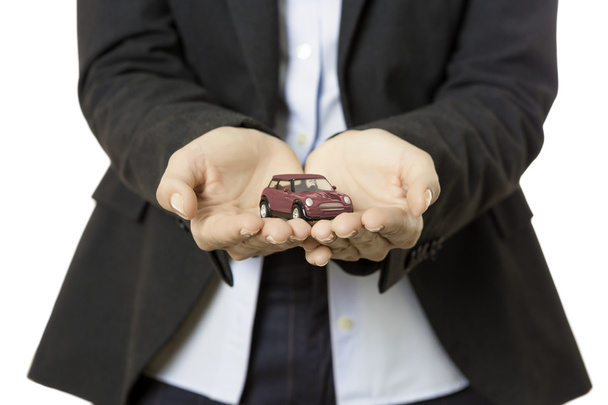 Business woman presenting a toy car - Photo, image