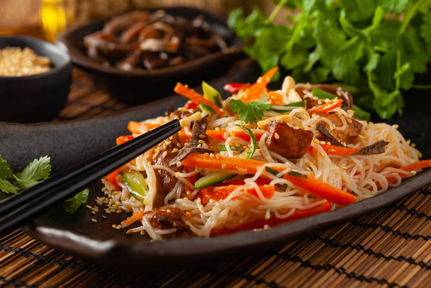Oriental salad with rice noodles, chicken and mint. Front view. - Foto, afbeelding