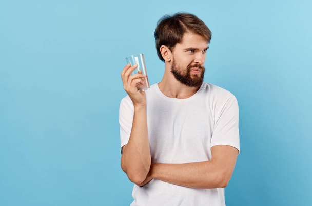 bearded man  with glass of water on  blue background. High quality photo - Fotó, kép