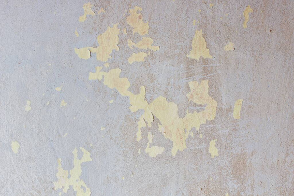 Getextureerde onbehandelde betonnen muur met stukjes lichtgroene verf en strepen - Foto, afbeelding