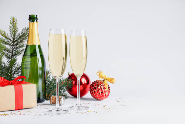 Happy New Year! Bottle of sparkling wine, glasses and festive decor on white background, space for text - Foto, Imagem