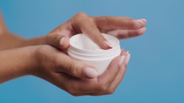 Onherkenbare vrouw houden Moisturizer Cream pot over blauwe achtergrond - Video