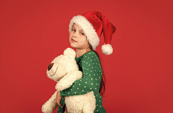 Polar bear. Shopping christmas gifts. Christmas holiday. Winter cheerful season. Xmas shopping sale. Little santa with toy. Small girl santa claus hat red background. Teddy bear. Christmas vibes - Foto, Imagen
