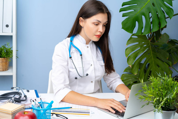 Young nice female doctor working in her office - Photo, image