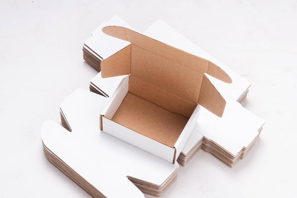 Lot of unfolded cardboard boxes ov wooden desk - Fotografie, Obrázek