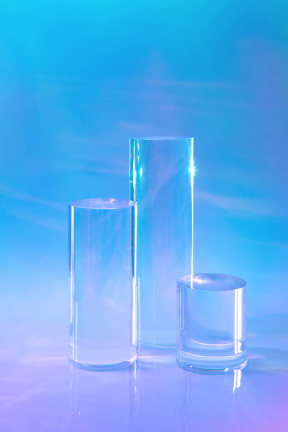 tres podios de cilindro de vidrio transparente sobre fondo holográfico de neón  - Foto, Imagen