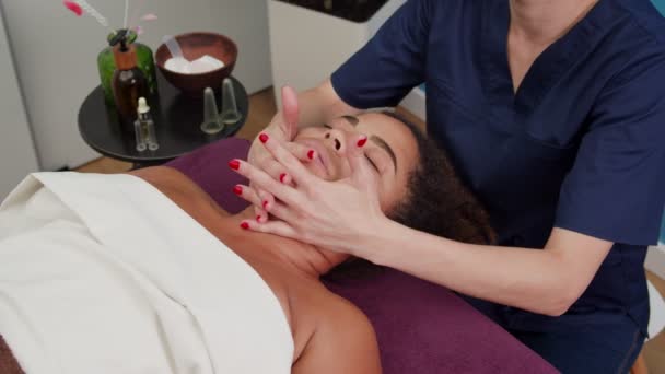 Kvalifikovaný specialista masáže dolní části obličeje ženy uvnitř - Záběry, video