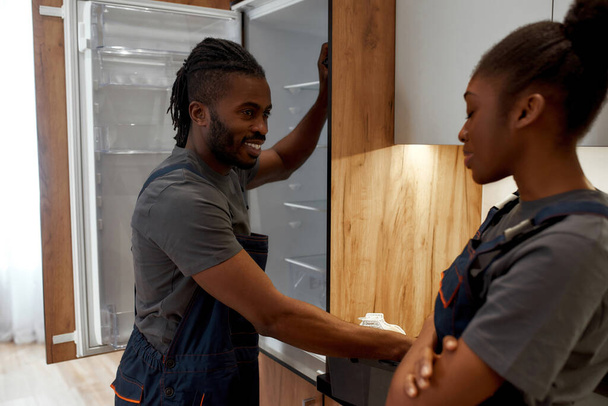 African American handyman flirting with young female apprentice - Foto, Imagen