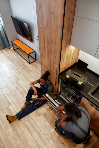 High angle reapir service workers on kitchen floor - Photo, image