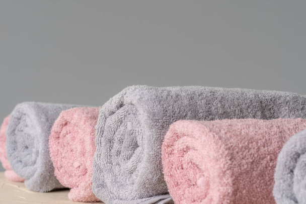 Pile of clean new towels against grey wall - Foto, Bild