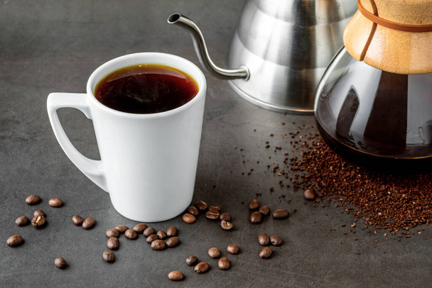 1杯のコーヒーと3代目が石床にコーヒー醸造設備を注ぎます。 - 写真・画像