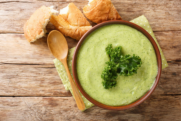 Delicious homemade kale puree soup close-up in a bowl on the table. horizontal top view from abov - Zdjęcie, obraz
