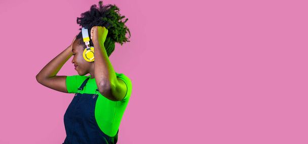 młody kręcone włosy czarny kobieta odizolowane taniec słuchanie muzyki z bezprzewodowy słuchawki -przycięte reklamy copyspace - Zdjęcie, obraz