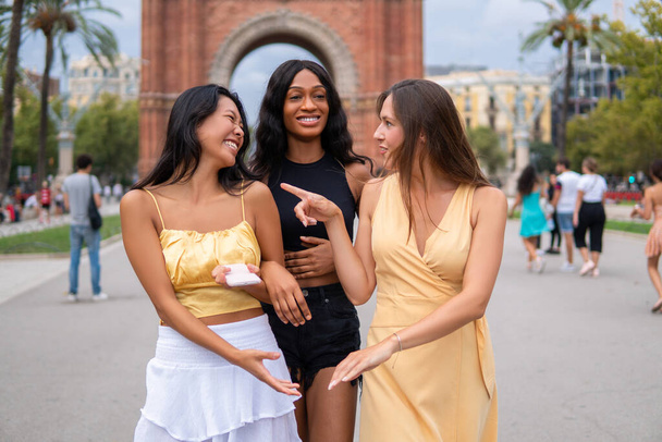 Többnemzetiségű barátnők beszélgetnek a város utcáin - Fotó, kép