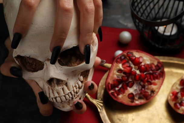 Злая ведьма с черепом за столом, крупным планом - Фото, изображение