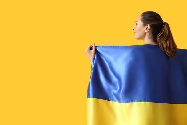 Молодая женщина с украинским флагом на цветном фоне - Фото, изображение