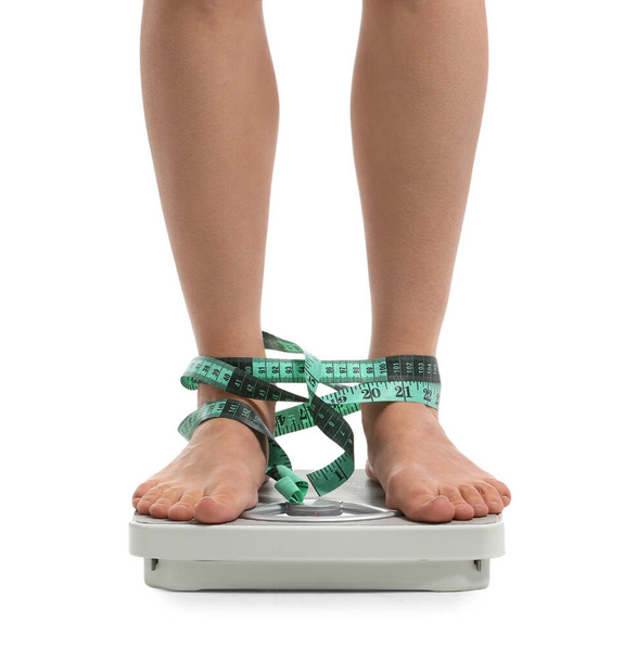 Junge Frau misst ihr Gewicht auf weißem Hintergrund. Magersucht-Konzept - Foto, Bild