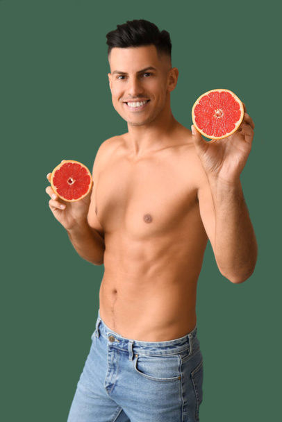Young man with grapefruit on color background. Vegan Day - Fotografie, Obrázek