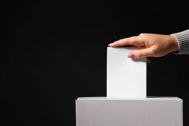 Voting woman near ballot box on dark background - Fotoğraf, Görsel