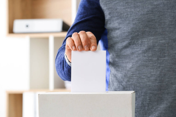 Człowiek głosujący w lokalu wyborczym - Zdjęcie, obraz
