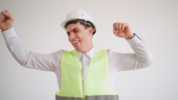 Joyeux constructeur en casque blanc et chemise se réjouit à la fin de la construction - Séquence, vidéo