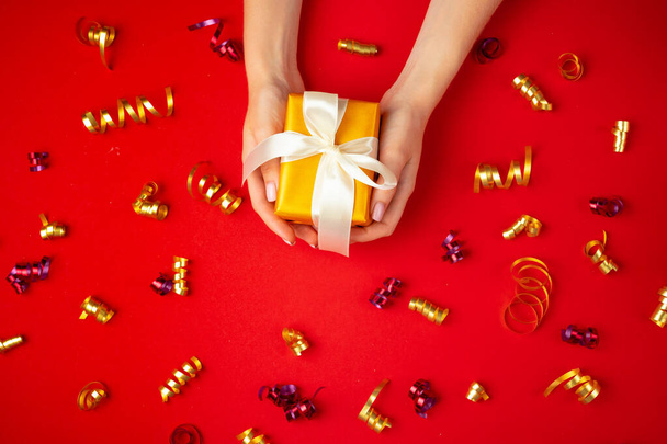 Woman hands holding gift box top view - 写真・画像