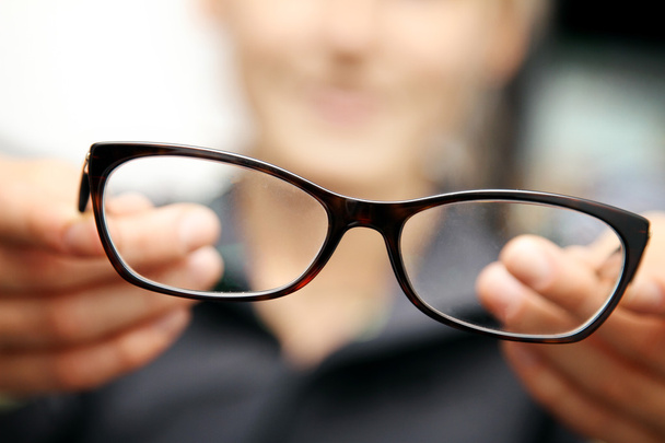 woman hands hold eyeglasses in front of her - Fotografie, Obrázek