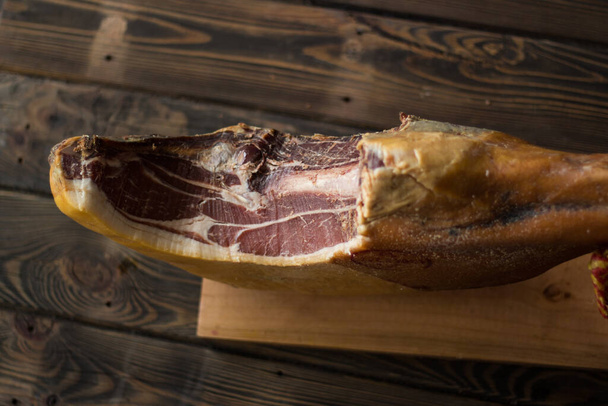 Whole serrano ham on a wooden table background. - Photo, Image