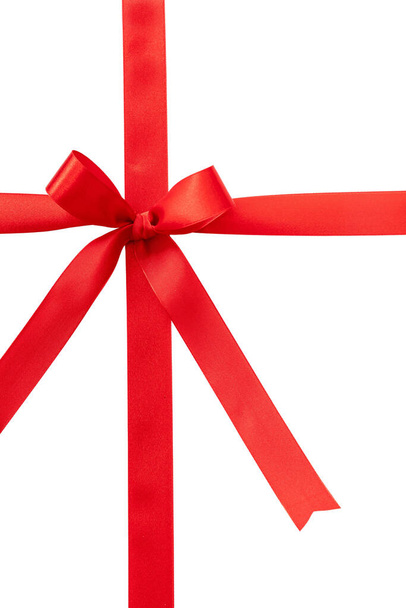 Piros szalag íj karácsonyi ajándék szatén göndör dekoráció, elszigetelt fehér háttérrel. Valentin, ünnepi ajándék design elem, felülnézet. - Fotó, kép
