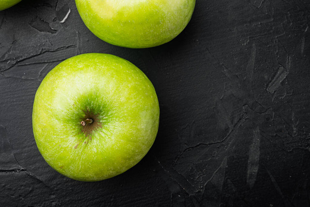Several ripe green apples set, on black dark stone table background, top view flat lay, with copy space for text - Fotografie, Obrázek