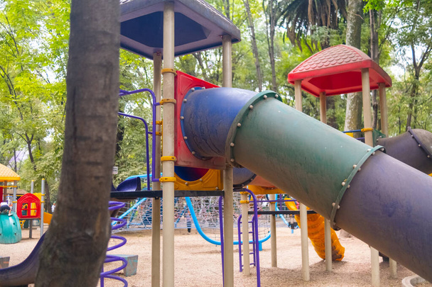 Toboggan de terrain de jeu coloré au milieu d'un parc - Photo, image