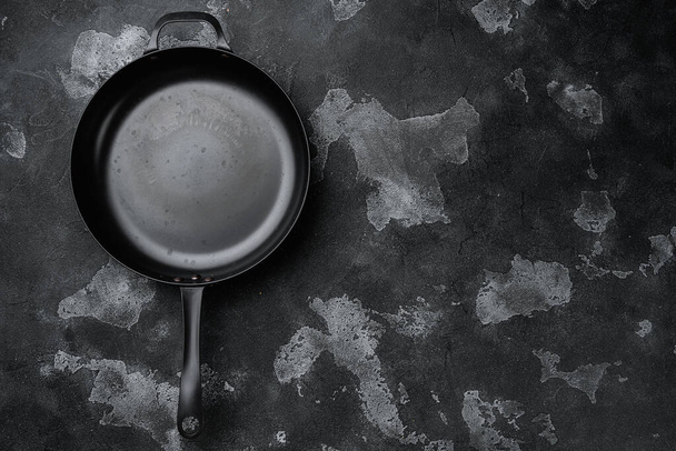 Used old empty frying pan set with copy space for text or food with copy space for text or food, top view flat lay, on black dark stone table background - Photo, Image