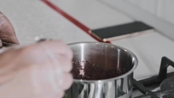 白いキッチンの女性シェフは鍋に電気ストーブの上でチェリーと砂糖を溶かす - 映像、動画