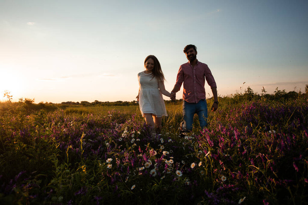 Lovely couple walking in the summer field - Фото, изображение