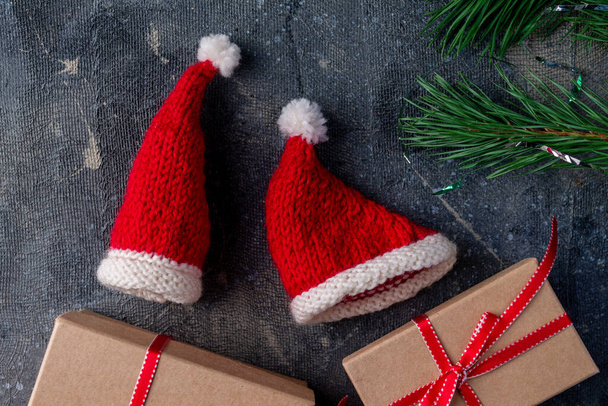 Sombreros de Papá Noel, regalos, rama de pino sobre fondo azul - Foto, imagen