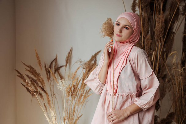 Retrato de la hermosa mujer árabe musulmana con vista lateral de hijab rosa. Foto de alta calidad - Foto, Imagen