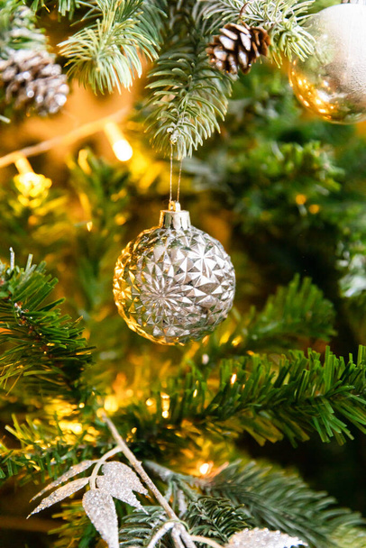 Klassieke kerstversiering Nieuwjaarsboom. Kerstboom met wite en zilveren decoraties, ornamenten speelgoed en bal. Modern klassiek stijl interieur appartement. Kerstavond thuis - Foto, afbeelding