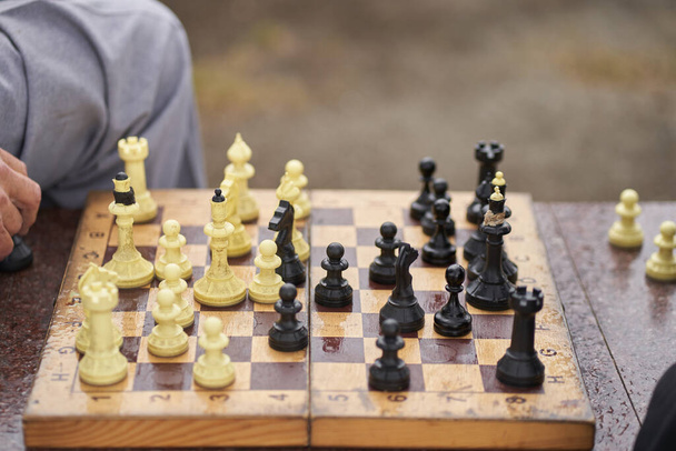 Δύο άντρες παίζουν σκάκι. Σκάκι επιτραπέζιο παιχνίδι έννοια των επιχειρηματικών ιδεών και του ανταγωνισμού και στρατηγικό σχέδιο η έννοια της επιτυχίας - Φωτογραφία, εικόνα
