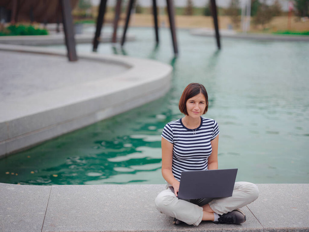studente donna che lavora con il computer portatile nel parco del campus. - Foto, immagini