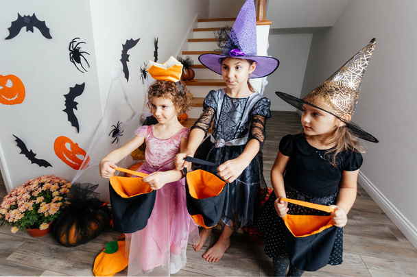 Girls receiving bunch of candies during halloween trick or treating - 写真・画像