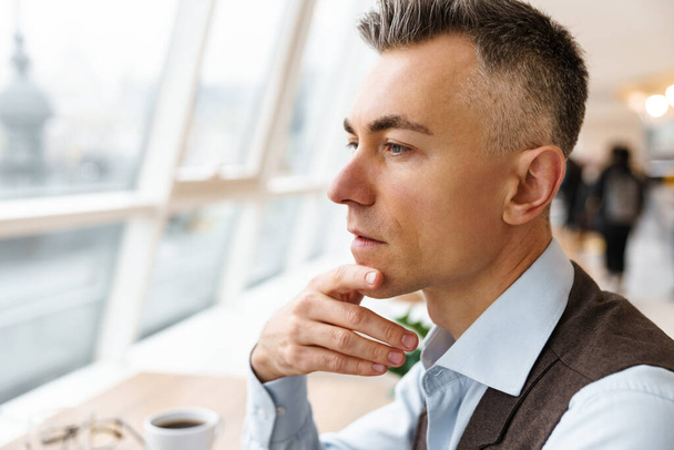Confident pensive business man in cafe indoors, close up - Fotó, kép