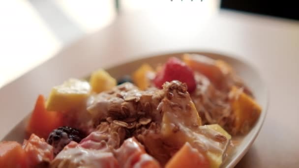 Πιρούνι σκάλισμα φέτα φρούτων με κρέμα γάλακτος και βρώμης στην κορυφή - Πλάνα, βίντεο