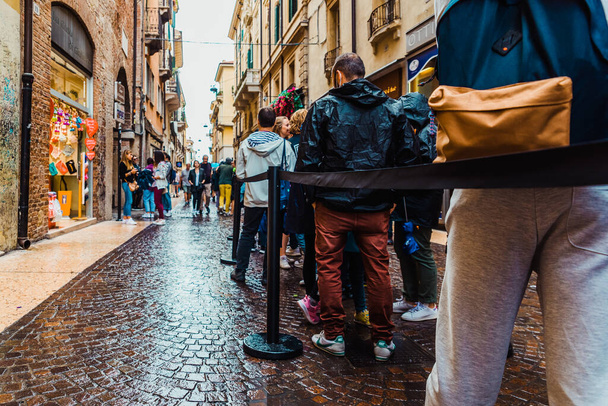 Verona, Italy - October 2, 2021: A long queue of tourists waits to enter to see Juliet and Romeo's house. - Valokuva, kuva