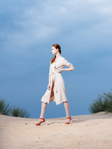 vrouw in jas poseren strand frisse lucht lifestyle mode - Foto, afbeelding