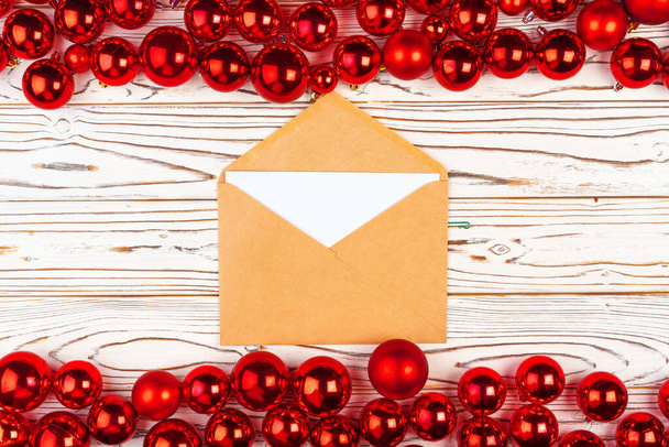 Świąteczna kartka z życzeniami lub list przeciwko zapleczu z czerwonymi bombkami - Zdjęcie, obraz